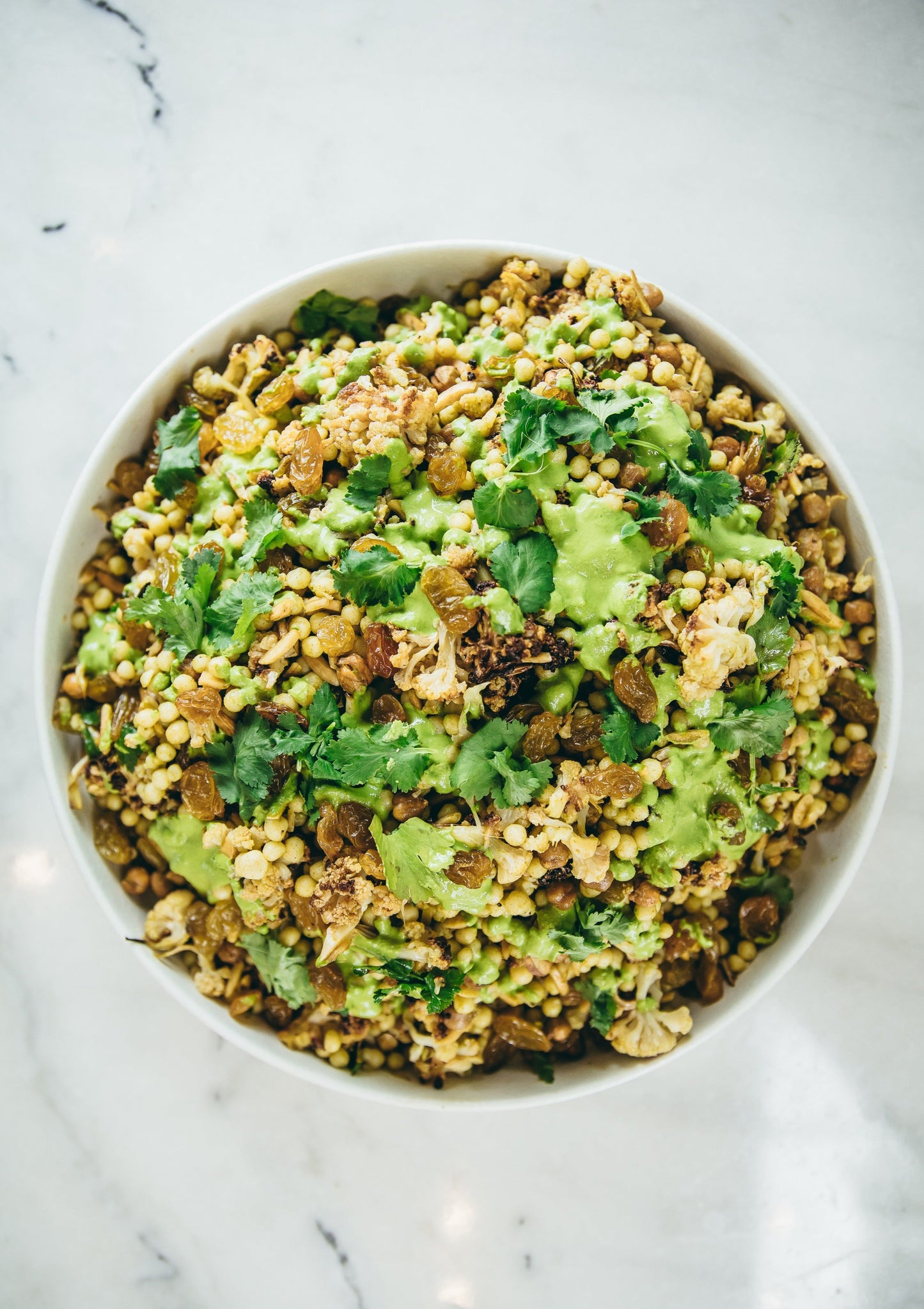Spiced roasted cauliflower, green tahini, chickpeas, cous cous, pickled onion, pomegranate, coriander & roasted almonds